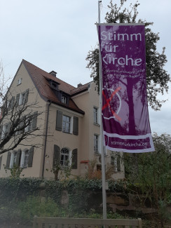 Stimm-fuer-Kirche-Fahne vor dem Pfarrhaus